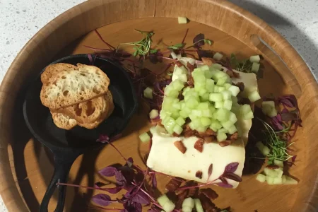 A plate of food on a table next to a bowl of food