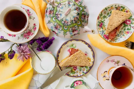 A table set with tea and turkey sandwiches.