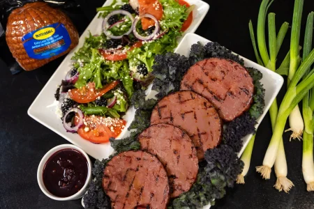 Turkey-Ham-1-scaled Sliced turkey ham cooked with BBQ sauce with salad on the side.