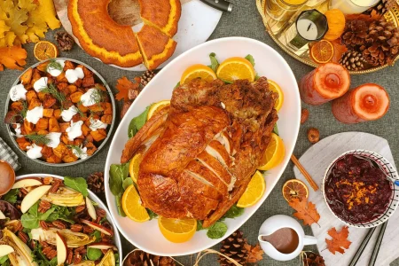 MicrosoftTeams-image-150-1-scaled Roasted whole turkey garnished with lemon with different assorted food items like potatoes, salad and gravy.