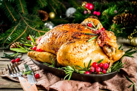AdobeStock_297318874-1-3-scaled Christmas whole turkey with cherries placed in a small tray.