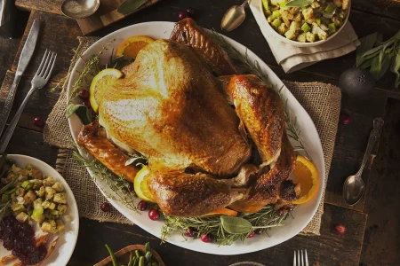 Roasted whole turkey garnished with cherries, lemon and turkey filling.