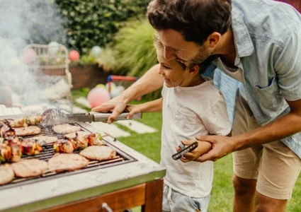 Father and son grilling turkey burgers in the backyard
