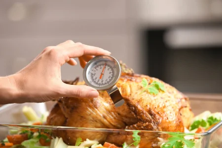 AdobeStock_168661807-scaled A person checking the temperature of a whole turkey