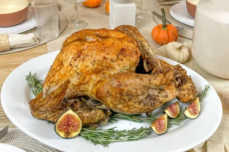 IMG_4779-min Cooked turkey with herbs and vegetables on a dining table.