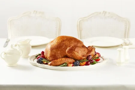 Option-16 Roasted whole turkey garnished with fruits placed on a table.